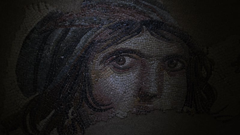 the gypsy girl mosaic, her eyes and hair in small stone tiles, lit low in the dark